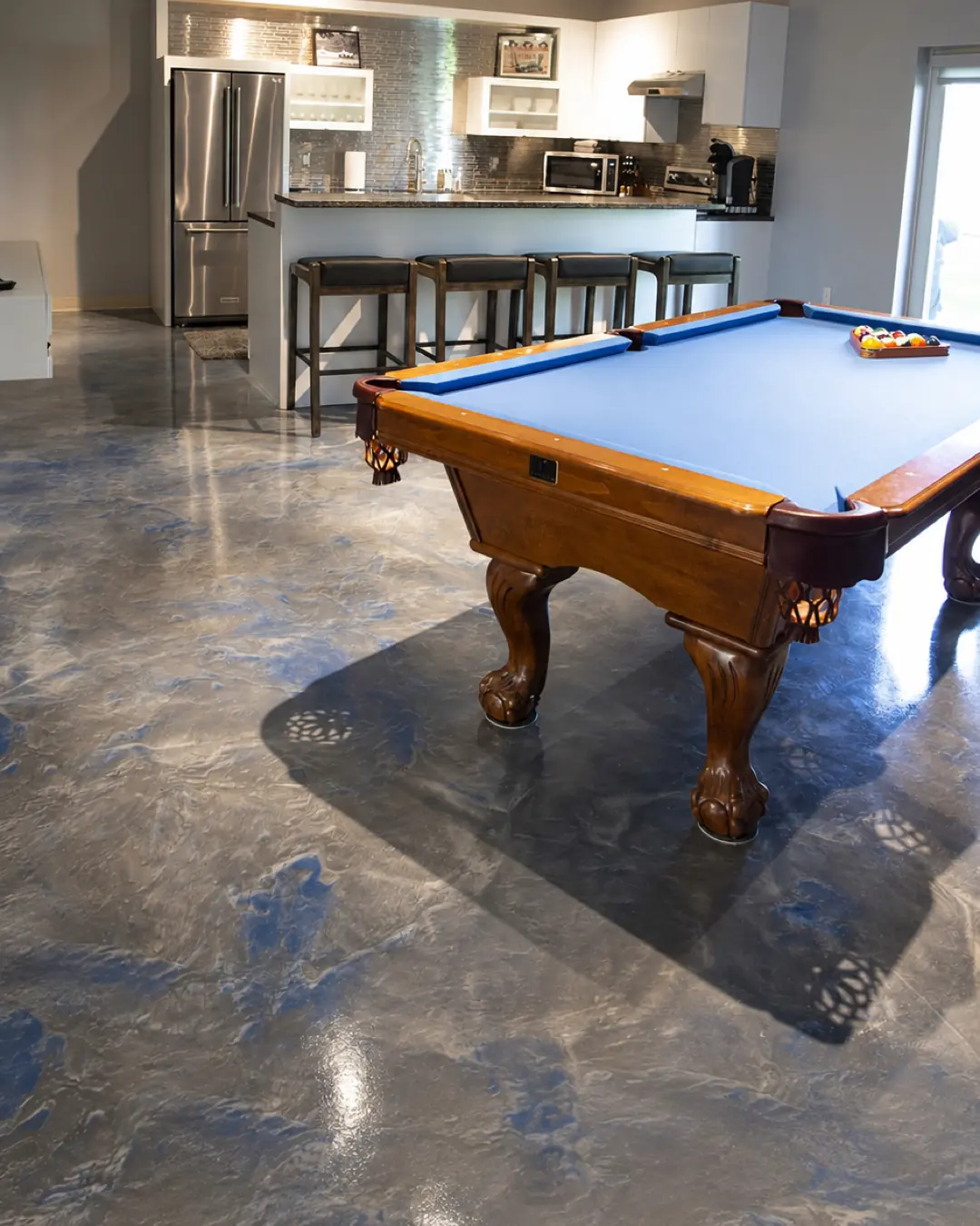 Sala de juegos con piso epóxico metálico gris azulado (imagen de referencia)