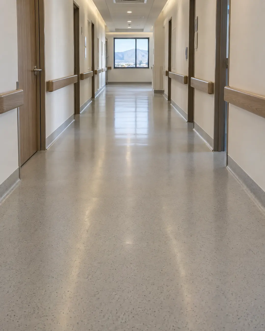 Pasillo de hospital con piso epóxico gris claro (imagen de referencia)